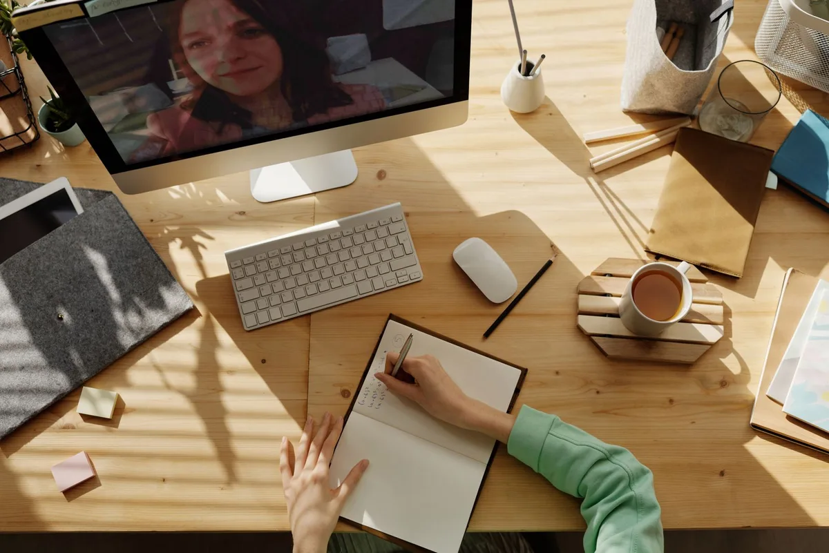 A parent helping a child learn at a laptop, representing an online school