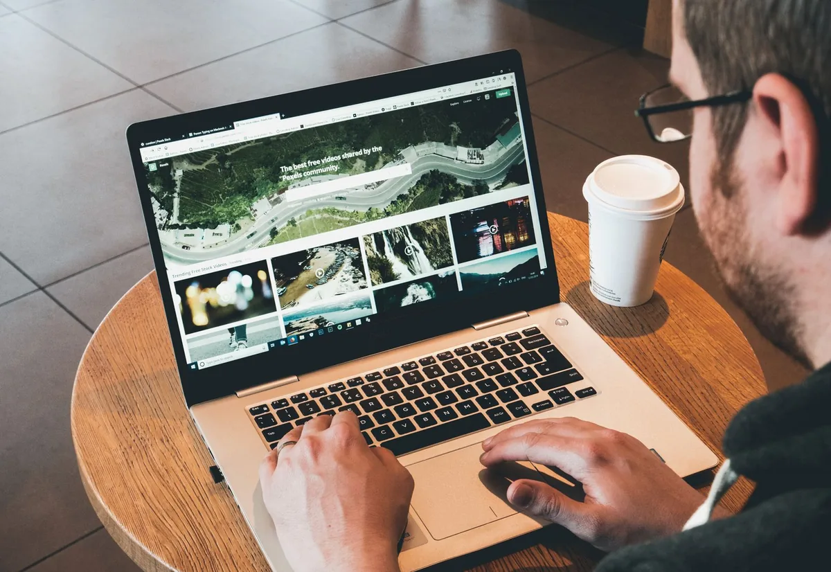 A person looking at a website on a laptop, considering a redesign